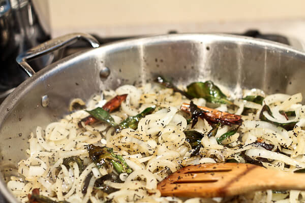 Sautéing whole spices, curry leaves and onions for Indian dish