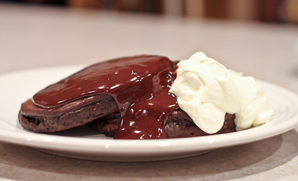 Chocolate Ganache Poured over Chocolate Pancakes with whipped cream