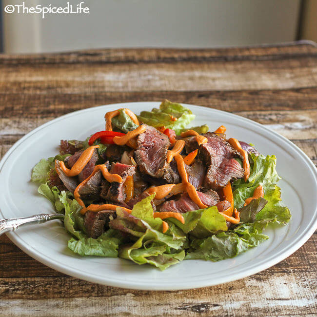 Marinated steak salad with roasted peppers and onions, and a tangy Romesco dressing.