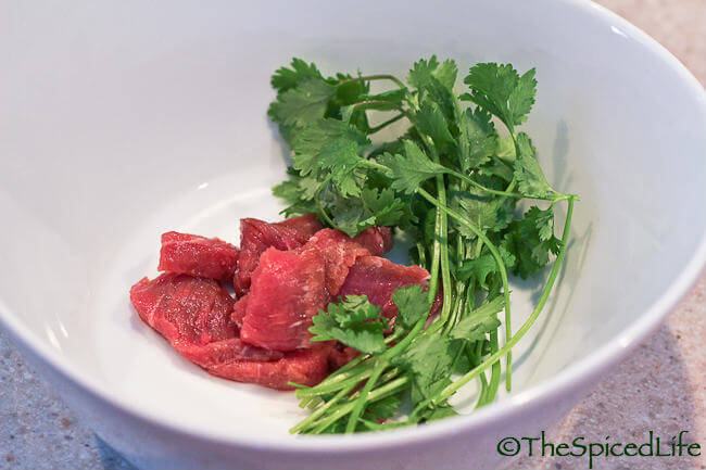 Raw steak and herbs waiting for boiling pho